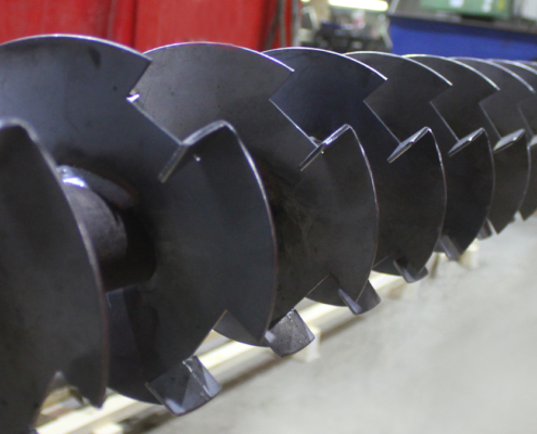 Schneckenwelle mit gekanteten Ausklinkungen an den Schneckenflügeln